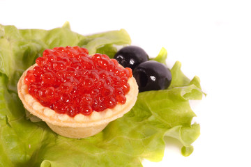 Caviar on sheet of salad with olives