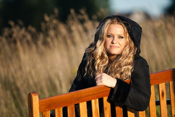 Fashionable girl sitting on the bench.