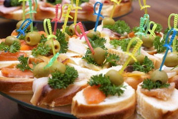Open sandwiches with red and white fish, olives and greens