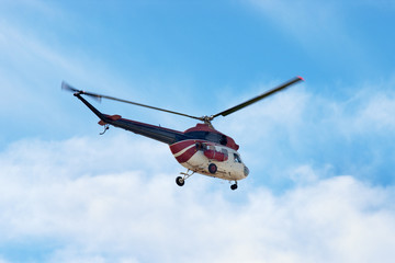 MI-2 Russian helicopter flying in blue sky with white clouds