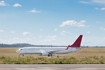 Passenger airplane on the airfield runway with blue sky