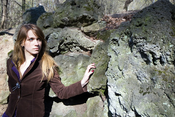 Beautiful young woman stand near stone wall