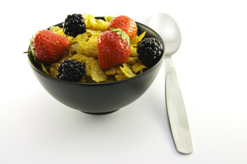Cornflakes and Fruit in a Black Bowl with a Spoon