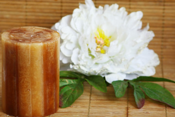candle and peony on bamboo mat horizontal