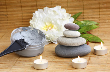face and body mask, pebbles, flower and burning candles