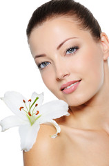 Fototapeta premium Face of health woman with lily close her face