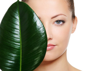 green leaf shading a half of beautiful woman face