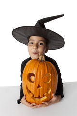 Little witch with a Halloween pumpkin