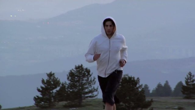 Ragazzo in tuta corre all'imbrunire