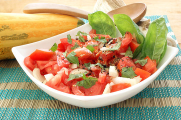 organic tomato salad in bowl with onion and basil
