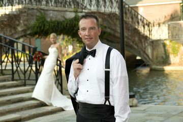 Groom with Bride in background