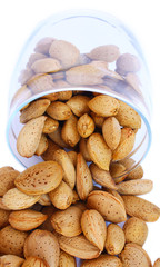 isolated pour out from glass jar almonds