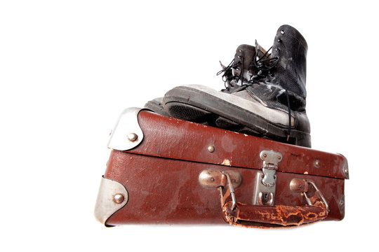 Fototapeta old good boots at vintage suitcase isolated on white