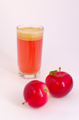 red apples and glass with juice on back plane