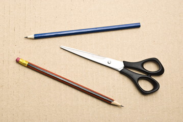 Scissors and pencils on cardboard background