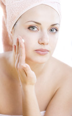 young woman with facial cream on her hand