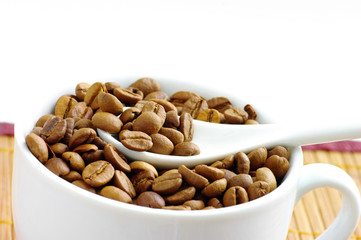 Cup and coffee beans, isolated over white background