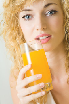 Happy young woman with juice of tropical fruit