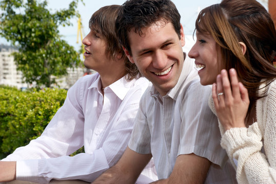 Group of young guys and girl sitting together