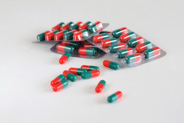 Red and green capsules on a white background