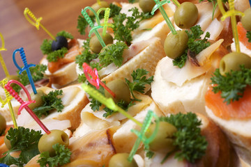 Open sandwiches with red and white fish, olives and greens