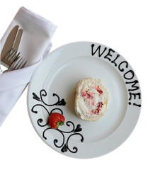 White plate with welcoming chocolate sign and cake