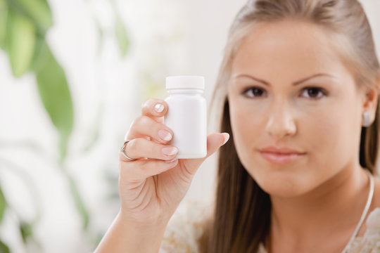 Woman showing pill bottle