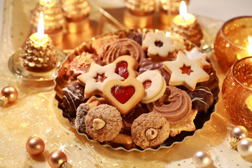 Delicious Christmas cookies with candles in golden tone
