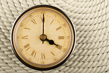 Clock with Roman numerals on cord background. 4