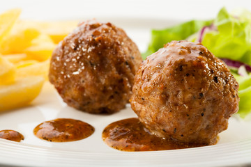 Roasted meatballs, fries and vegetable salad