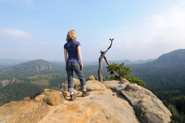 Frau steht auf Felsen im Elbsandsteingebirge