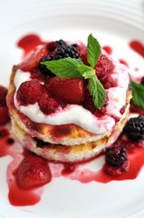 Individual cheesecake with summer berries on the plate.