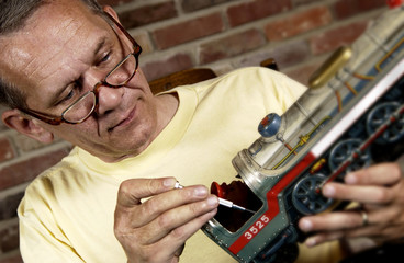 Man repairing a model train