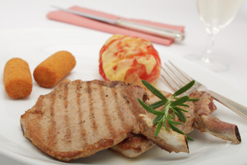 Schweinekoteletts mit Kartoffelkroketten und Grilltomate