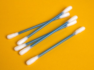 Cotton sticks on yellow background