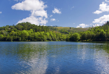 Beautiful landscape with lake in forest and clouds