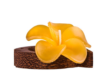 Yellow candle in the form of a flower on a wooden support