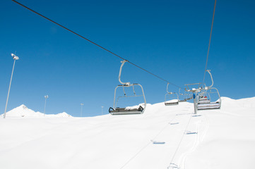 Ski lift chairs on bright winter day