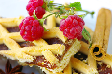 Plum cake with raspberry and stick of cinnamon
