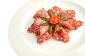 salami on white plate close up