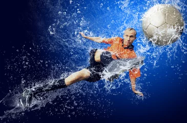 Fototapete Wassertropfen um Fußballspieler unter Wasser auf blauem Hintergrund © Andrii IURLOV