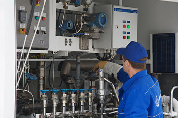 Worker standing at control sensors of a truck for cooled liquids