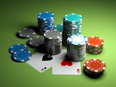poker chips with two aces on green casino table