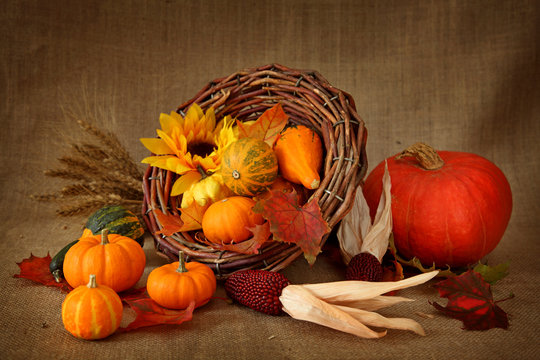 Cornucopia with pumpkins on brown background