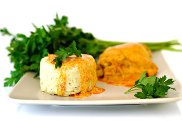 Rice with paprika chicken sauce and parsley on plate