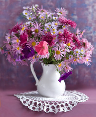 cup of tea and a bouquet of flowers in a white jug