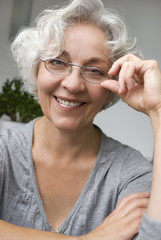 attraktive, ältere Frau mit Brille lächelt