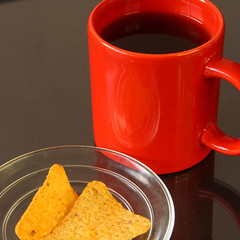 Red mug and chips on glass plate