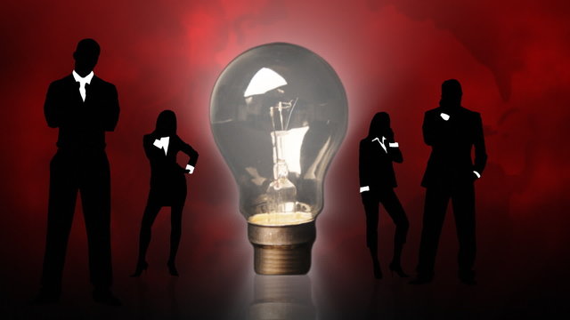Business people silhouettes and a lightbulb. Concept of clever