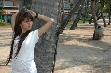 young lady get posed beside coconut tree